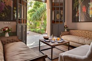 馬拉喀什的住宿－德奧廣場酒店，客厅配有沙发和带玻璃杯的桌子