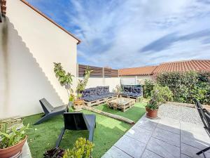 un cortile posteriore con patio, tavolo e sedie di Villa 6 couchages avec jardin a Ortaffa