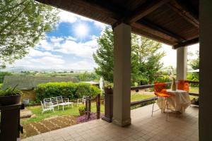 a patio with a table and chairs on a porch at colle del mondo country house in Collecorvino