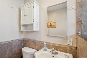 a bathroom with a toilet and a sink and a mirror at Lovely 1 Bed Beach Condo #128 in Carpinteria +19 photos