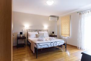 una camera da letto con un letto grande con cuscini bianchi di Atrium Villa Syvota a Sivota