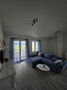 a living room with a blue couch and a table at Apartmani 1 Pinezici in Pinezici