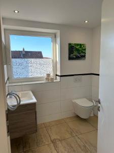 a bathroom with a window and a toilet and a sink at City Appartments in Braunschweig