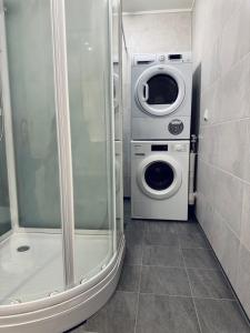 a washing machine and a washer and dryer in a bathroom at EideKollen in Tromsø