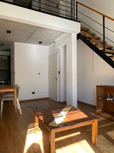 a living room with a table and a loft at Duplex San Martín in Lobos +1 photo