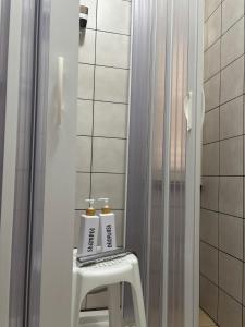 a bathroom with two bottles on a stool next to a shower at Blue Tide - Tropea in Tropea