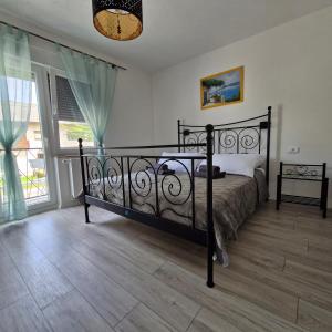 a bedroom with a bed and a large window at Vila Natasa Apartment 3 near Plitvice in Vrhovine