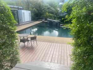 a patio with a table and chairs next to a pool at Le Grand Bleu in Koh Samui