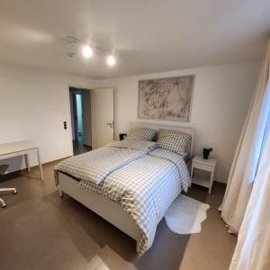 a bedroom with a bed with a checkered bedspread at Esmeralda Ferienwohnung mit Sonnenterrasse & großem Parkplatz in Ebersbach-Musbach