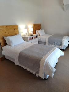 a hotel room with two beds and a room with two lamps at KarooRus in Burgersdorp