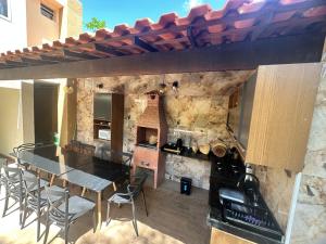 a kitchen with a table and chairs and a stone wall at Suites Holanda in Guaramiranga