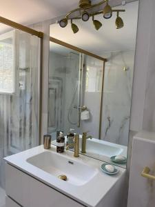a white bathroom with a sink and a shower at Cap Corse, T3 Spacieux à Erbalunga Village Typique & Plage à Pied in Brando