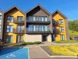 an apartment building with a parking lot in front of it at Apartament Lake & Hills Karkonosze nad Zalewem Sosnówka Karpacz in Sosnówka