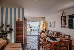 a living room with a table and a couch at Casa beira-mar 25km do aeroporto de Recife in Cabo de Santo Agostinho