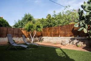 two chairs sitting in a yard next to a fence at Kamera House - 10 min to Seitan Limania Beach in Khordhákion