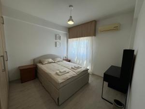 a small bedroom with a bed and a window at 2 BR apartment in the Limassol with sea view in Limassol