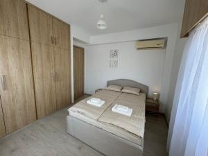 a bedroom with a bed and wooden cabinets at 2 BR apartment in the Limassol with sea view in Limassol
