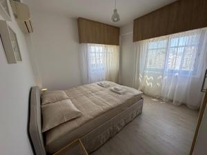 a bedroom with a bed in a room with windows at 2 BR apartment in the Limassol with sea view in Limassol