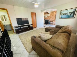 a living room with a couch and a flat screen tv at Apartamento Eco City 01 Privativo, Espaçoso e Confortável Com Garagem in Curitiba