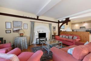 a living room with pink couches and a fireplace at Llanfor in Fishguard