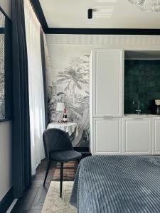 Un dormitorio con una cama, una silla y una mesa. en Belle époque appartement I The Artdrake Collection by LUX RELAX Apartamenty Kołobrzeg, en Koszalin 5 fotos más