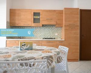 een keuken met een tafel met daarop een laptop bij RS317 - Marcelli, bilocale in residence fronte mare in Marcelli