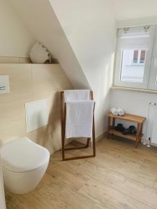 a white bathroom with a toilet and a window at Stuv Mariken - Apartment in Warnemünde in Rostock