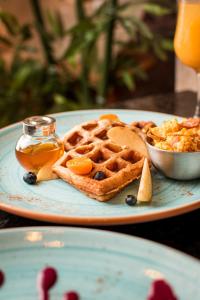 a plate of waffles and syrup on a table at Mantra Hotel Boutique in Santa Marta