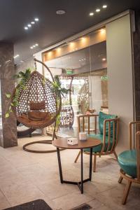 a room with a table and chairs and a swing at Mantra Hotel Boutique in Santa Marta