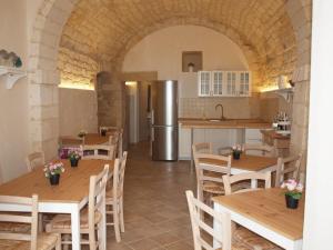 a kitchen and dining room with wooden tables and chairs at Agriturismo Arà in Casale Zappulla