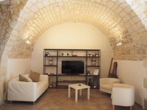 a living room with a white couch and a tv at Agriturismo Arà in Casale Zappulla