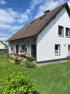 una casa blanca con un patio de césped en Haus Sengbach im Bergischen Land mit 2 Schlafzimmern, en Leichlingen