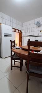 een keuken met een houten tafel en een koelkast bij Casa Térrea em Correntina in Correntina +29 foto's