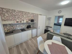 a living room with a couch and a kitchen at Apartman Centrum Mudronova in Košice
