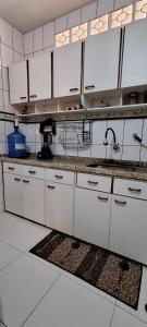 een keuken met witte kasten en een spoelbak bij Casa Térrea em Correntina in Correntina