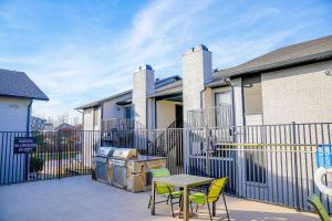 a patio with a table and chairs in front of a fence at The Chandler 1111 I Comfy 2 Bed 2 Bath in Grand Prairie