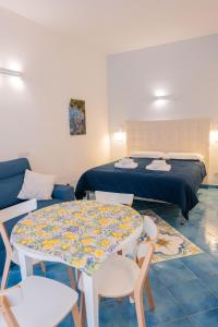 a room with a bed and a table and chairs at Divina Holiday - Apartments in Maiori