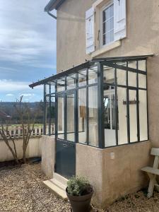 a glass conservatory on the side of a building at La Maison des Pérolles in Santenay +3 photos