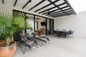 a patio with chairs and a table and some plants at Casa Guapinol - con vista al Campo de Golf in Tangolunda