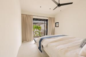 a white bedroom with a bed and a window at Casa Guapinol - con vista al Campo de Golf in Tangolunda +63 photos