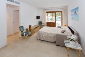 a bedroom with a bed and a desk and chairs at Apartamentos Sofía in Es Cana