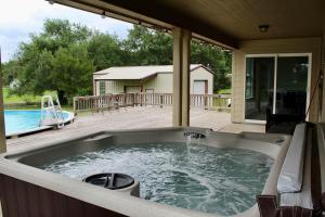 a hot tub on a deck next to a pool at Limestone Hideaway in Jewett