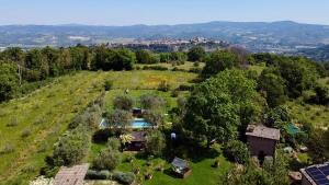 an aerial view of a field with a house and a pool at Dimora di Campagna La Cervaiola in Porano