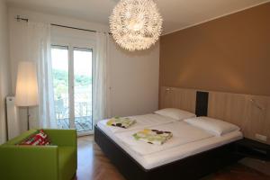 a bedroom with a large bed and a chandelier at Buchenheim Apartments in Reifnitz
