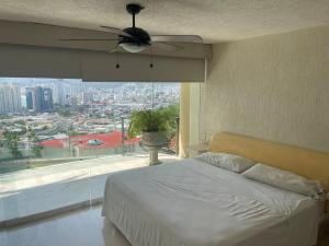 阿卡普尔科Brisa del Mar的一间卧室配有吊扇和大窗户