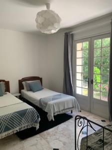 a bedroom with two beds and a chandelier at Riverside Retreat in Badefols-sur-Dordogne