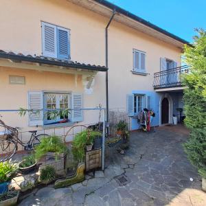 ein Haus mit blauen Fensterläden und Pflanzen im Innenhof in der Unterkunft Villa Atlantica B&B in Manerbio