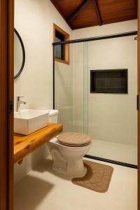 a bathroom with a toilet and a sink and a shower at La Playa Bangalô in Arraial d'Ajuda