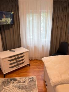 a bedroom with a bed and a dresser and a window at Apartament S 22 in Roman