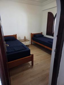 a bedroom with two beds and a door open at Terrasse sur l'azur in Taghazout